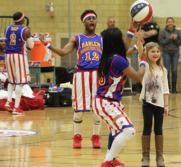 TNT helps a local Cheyenne elementary student spin a basketball on her finger while Ant cheers in the background.