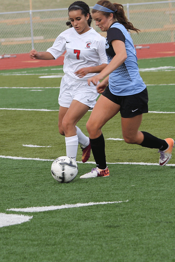Junior Ashton Horsely dribbles the ball during the rival game at Riske Field on April 10. The girls lost the game with a final score of 2-1.