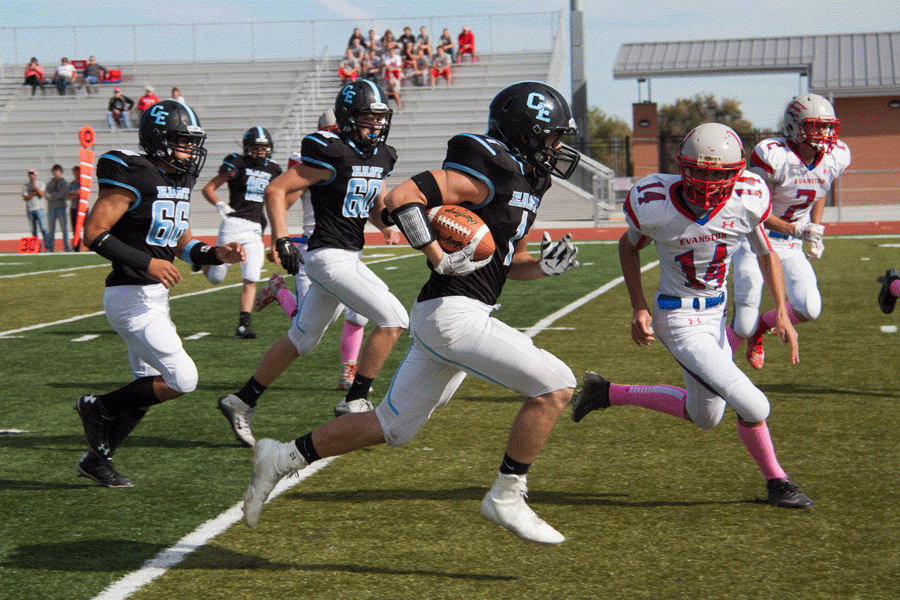 Lane Warren runs past evanston players for his first touchdown of the game.