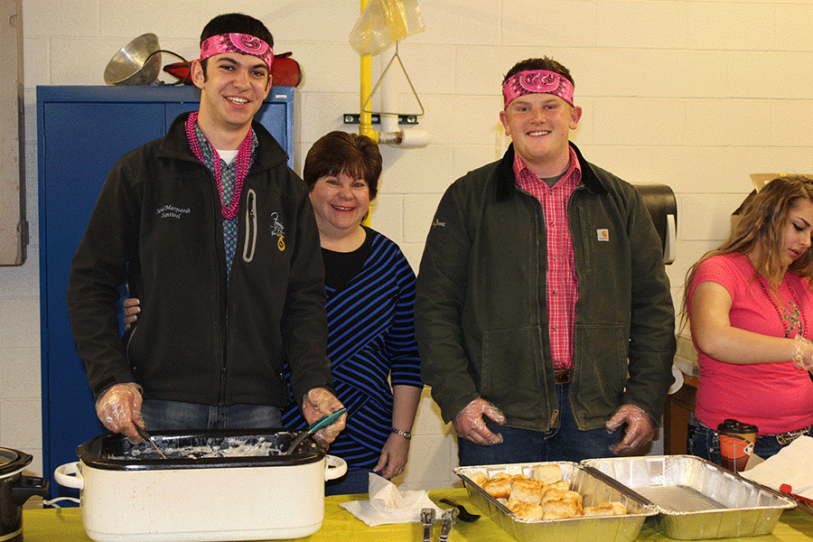 Junior Jared Marquardt, Mrs. Marquardt, and Garrett Hartigan serve biscuits and gravy at the FFA teacher breakfast