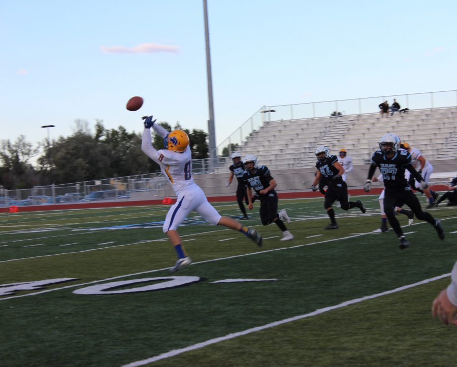 Number 8 of Sheridan catches the ball and the Thunderbirds chase after him for the ball.