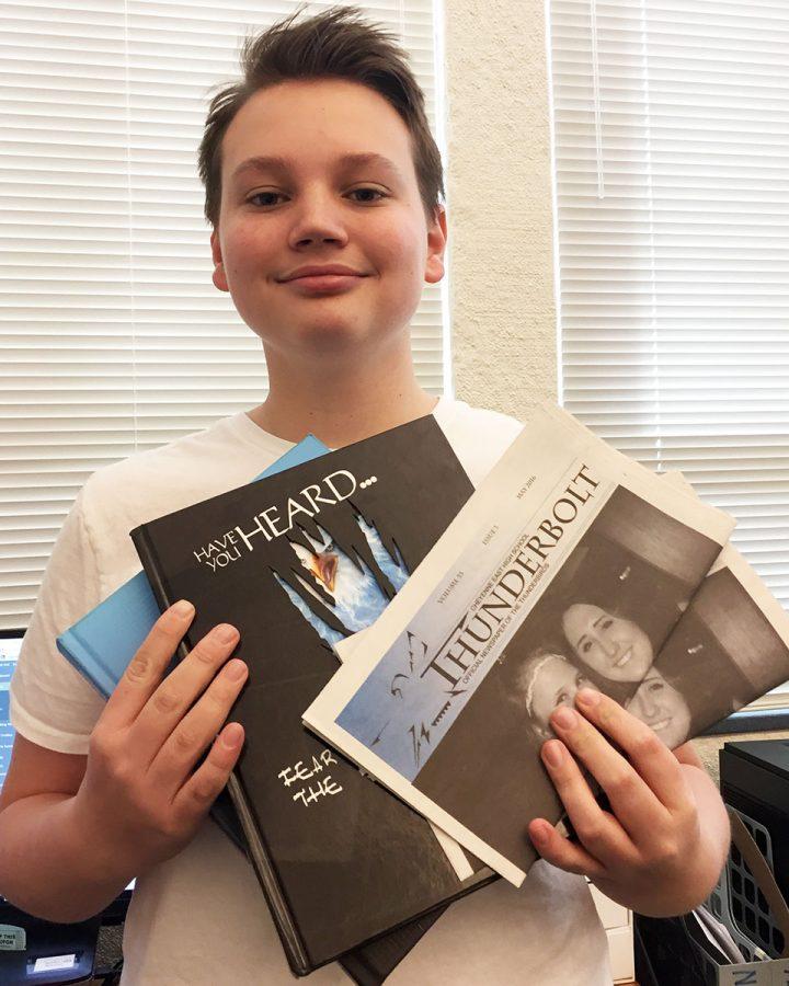 Camden Schmidt shows off the 2016 and 2015 East High yearbooks and an edition of the 2016 Thunderbolt. both publications were recognized at the WHSSPA convention as being tops in the state.