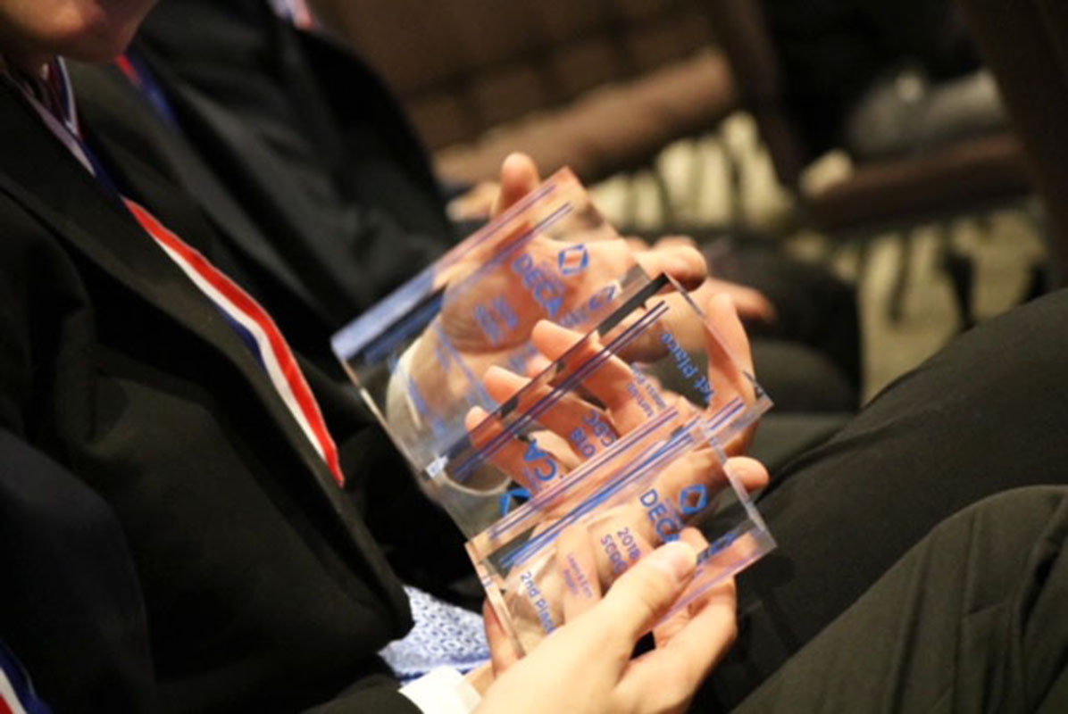 Senior Luke Macy shows his state DECA trophies to the camera. Macy and many other East DECA members will head to Atlanta in April to compete on the international level.