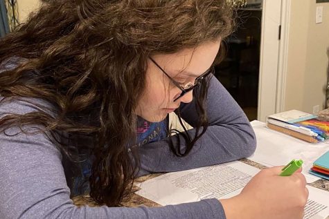 With pen in hand, junior Jaylen Burch takes notes in her readings. Many students printed off materials or asked for learning packets so they could do school work in a more traditional way, with pencil and paper.
