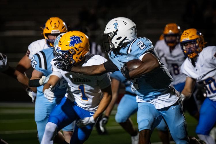 Sheridan linebacker Gauge Rodgers, left gets stiff-armed by Cheyenne East running back Keyshawn Brown during their Fryday night game at Okie Blanchard stadium in Cheyenne 